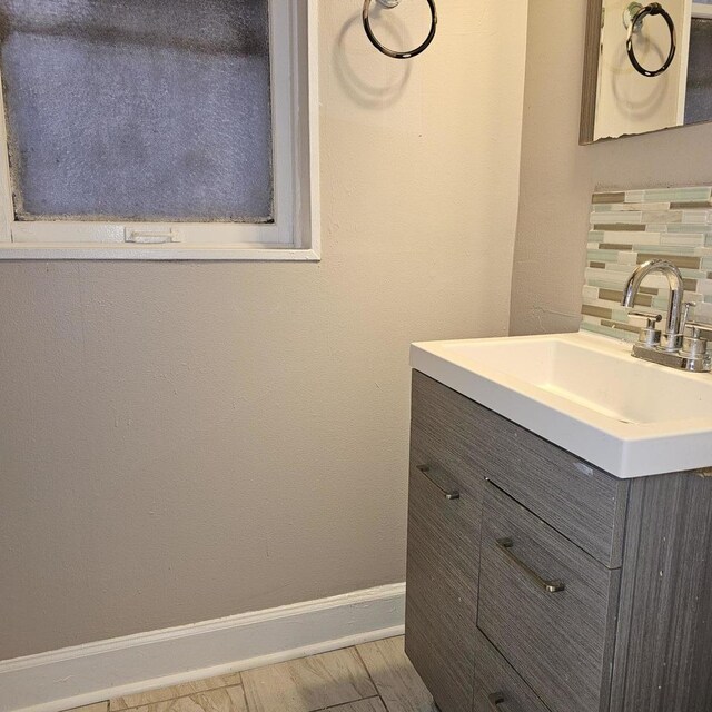 2251 S Kirkland Ave, Chicago, IL 60623 - bathroom with decorative backsplash, baseboards, vanity, and wood finished floors