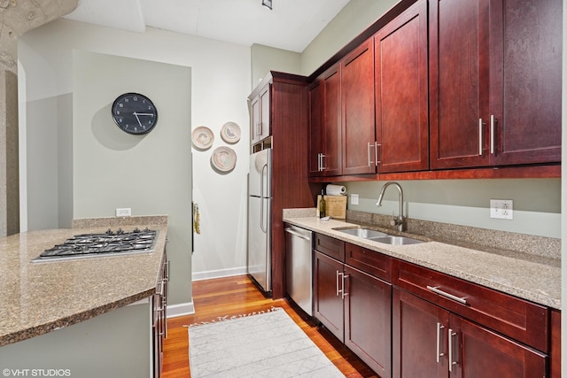 kitchen with reddish brown cabinets, a sink, and stainless steel appliances