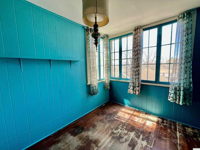 spare room featuring hardwood / wood-style floors and wooden walls