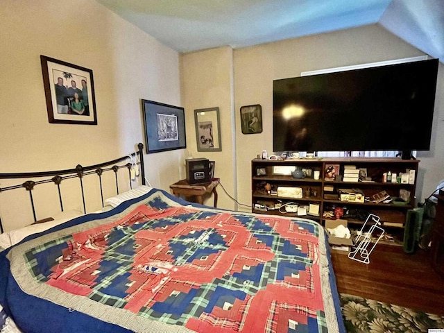 bedroom with lofted ceiling and wood finished floors