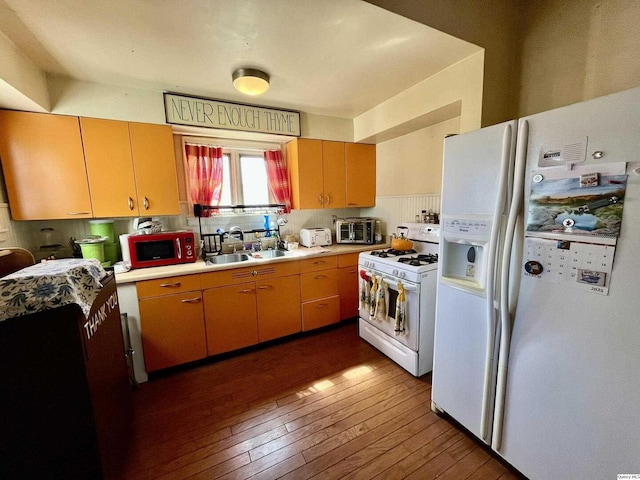 kitchen featuring light countertops, backsplash, a sink, white appliances, and dark wood-style flooring