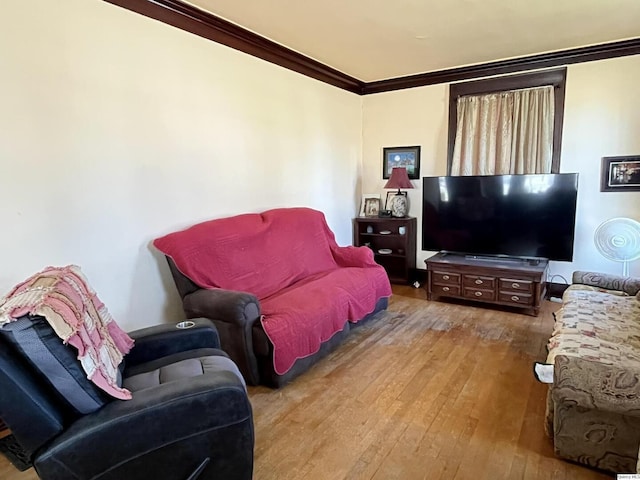 living area with hardwood / wood-style flooring and crown molding