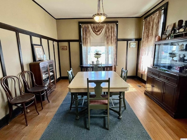 dining area featuring baseboards, crown molding, and wood finished floors