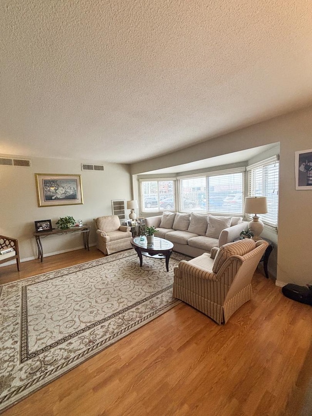 5500 Lincoln Ave Ave Unit 118E, Morton Grove, IL 60053 - living room featuring a textured ceiling, light wood-style flooring, and healthy amount of natural light