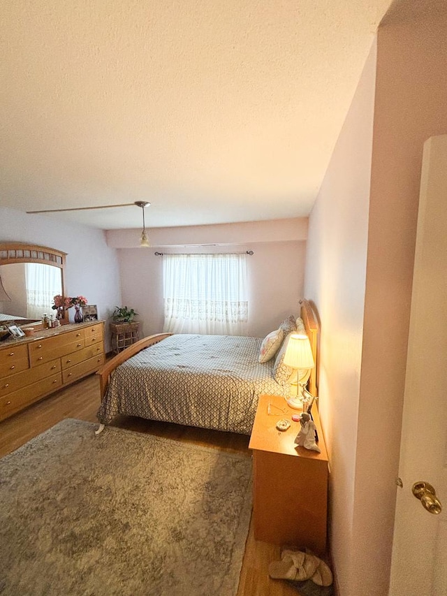 5500 Lincoln Ave Ave Unit 118E, Morton Grove, IL 60053 - bedroom with wood finished floors and a textured ceiling