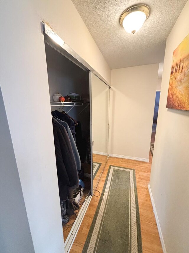 5500 Lincoln Ave Ave Unit 118E, Morton Grove, IL 60053 - hall featuring a textured ceiling and light wood-style flooring