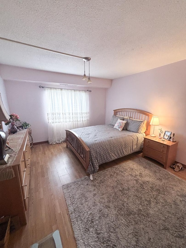 5500 Lincoln Ave Ave Unit 118E, Morton Grove, IL 60053 - bedroom with wood finished floors and a textured ceiling