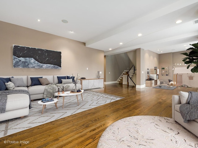 living room with recessed lighting, wood finished floors, and stairway