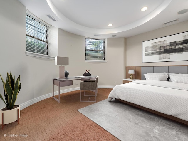 carpeted bedroom with recessed lighting, a tray ceiling, baseboards, and visible vents