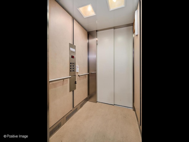 interior space with elevator and light carpet