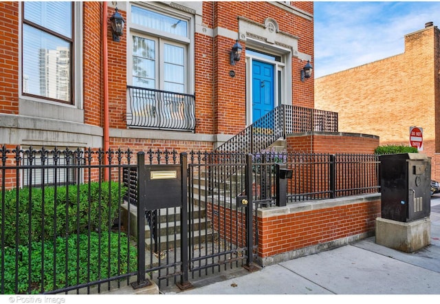 view of front facade with a fenced front yard, a gate, and brick siding