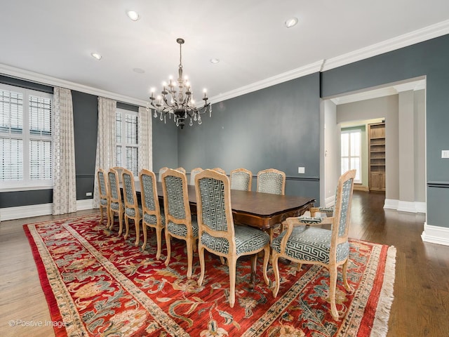 dining room with crown molding, baseboards, a chandelier, and wood finished floors