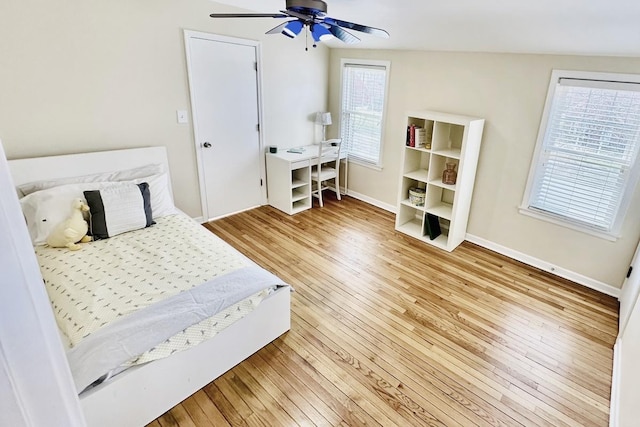 bedroom featuring light wood-style floors, a ceiling fan, and baseboards
