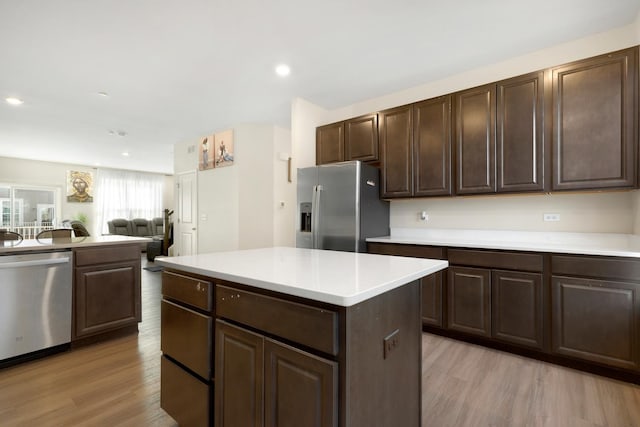 kitchen featuring light wood finished floors, light countertops, dark brown cabinetry, and stainless steel appliances