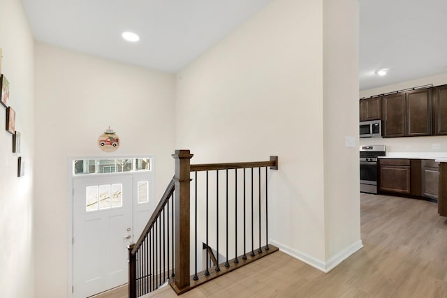 entryway with baseboards, light wood-style floors, and recessed lighting