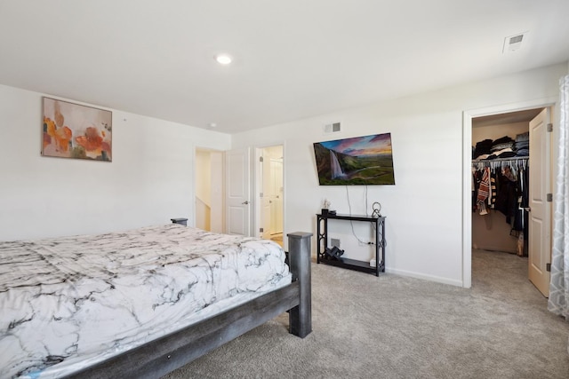 bedroom with light carpet, baseboards, visible vents, and a spacious closet