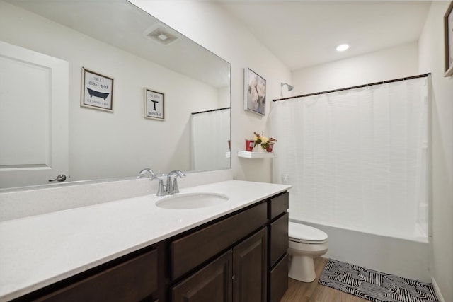 bathroom featuring vanity, toilet, visible vents, shower / bath combo, and wood finished floors
