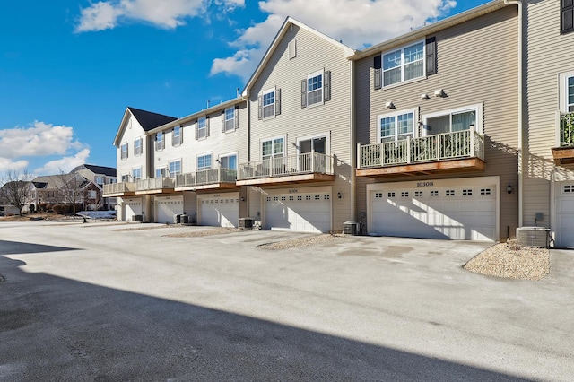 exterior space featuring a residential view, cooling unit, and a garage