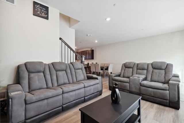 living area featuring recessed lighting, stairway, and light wood finished floors