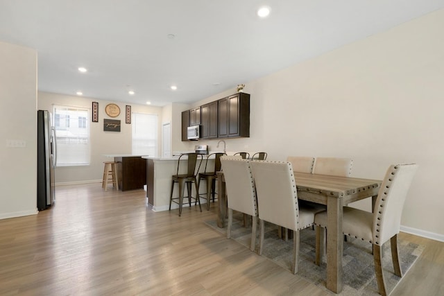 dining space with baseboards, light wood-style floors, and recessed lighting