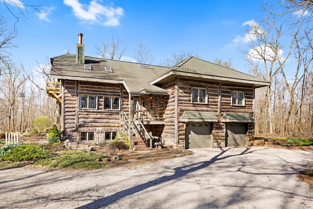 2655 County Road 550 E, Mahomet, IL 61853 - log-style house with stairway, a chimney, log siding, aphalt driveway, and a garage