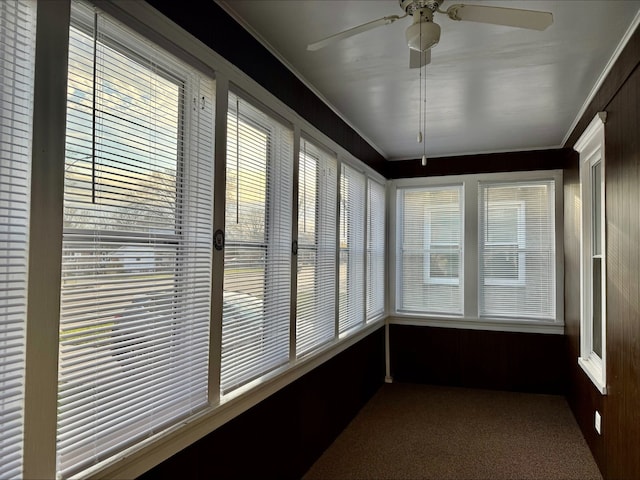 unfurnished sunroom with carpet flooring and ornamental molding