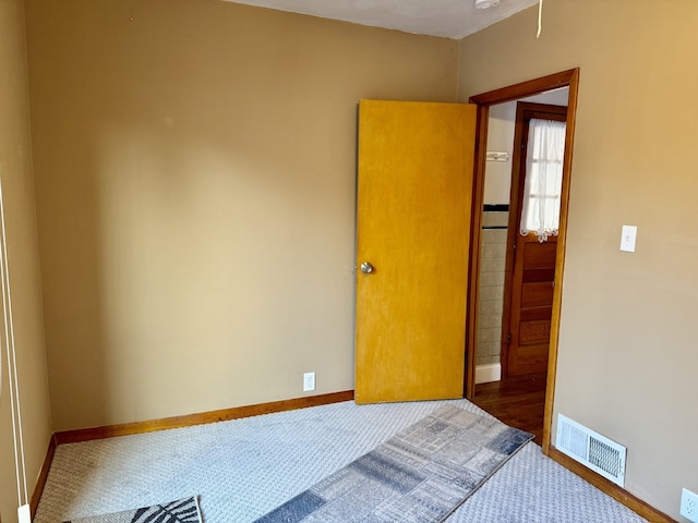 unfurnished bedroom featuring baseboards, visible vents, and carpet flooring