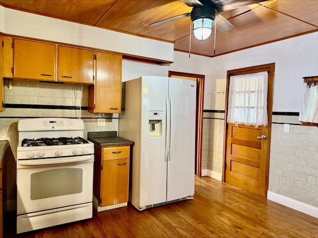 kitchen with white appliances, dark countertops, a ceiling fan, dark wood-style floors, and wood ceiling