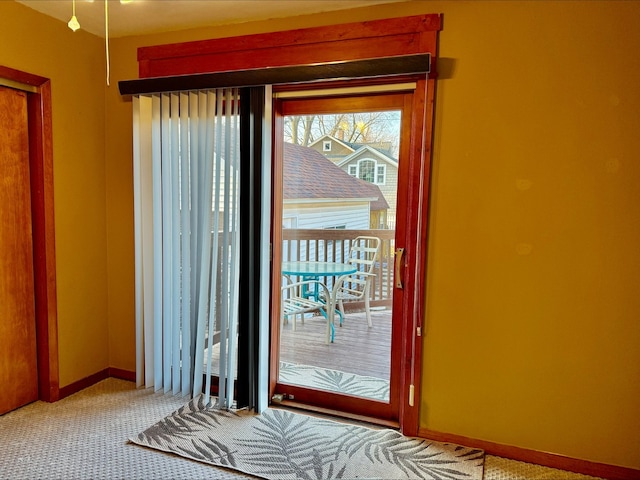 doorway with baseboards and carpet
