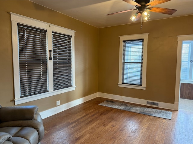 interior space with visible vents, baseboards, ceiling fan, and wood finished floors
