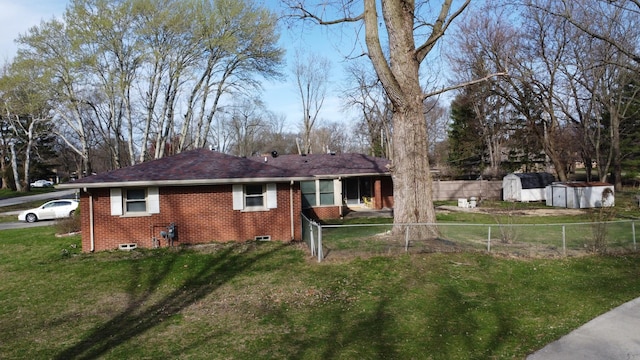 2775 E Riverview Dr, Kankakee, IL 60901 - back of property with an outbuilding, fence, a storage unit, brick siding, and a yard