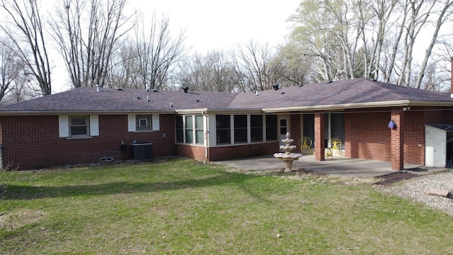 2775 E Riverview Dr, Kankakee, IL 60901 - back of property with a sunroom, central air condition unit, a patio, brick siding, and a lawn