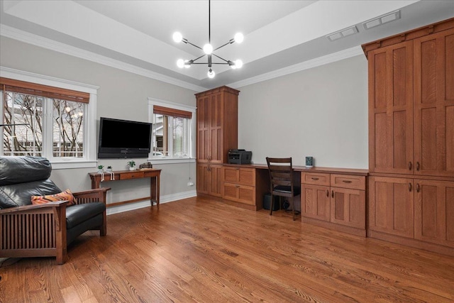 office space featuring a raised ceiling, a notable chandelier, crown molding, and light wood-style flooring