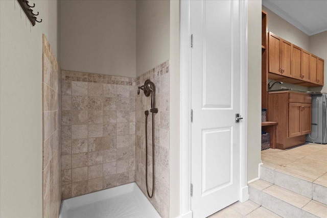 bathroom with crown molding, tile patterned flooring, and tiled shower