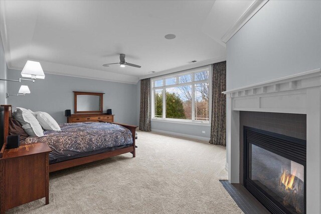 carpeted bedroom featuring a fireplace with flush hearth, baseboards, ceiling fan, and visible vents