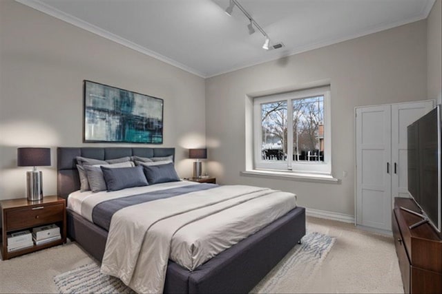 bedroom featuring rail lighting, light carpet, crown molding, and baseboards