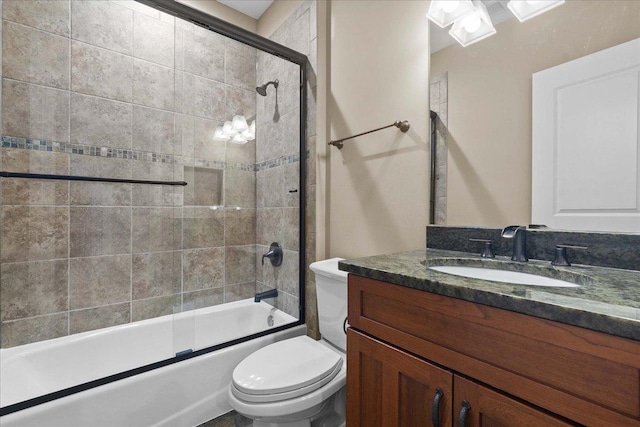 bathroom with toilet, shower / bath combination with glass door, and vanity