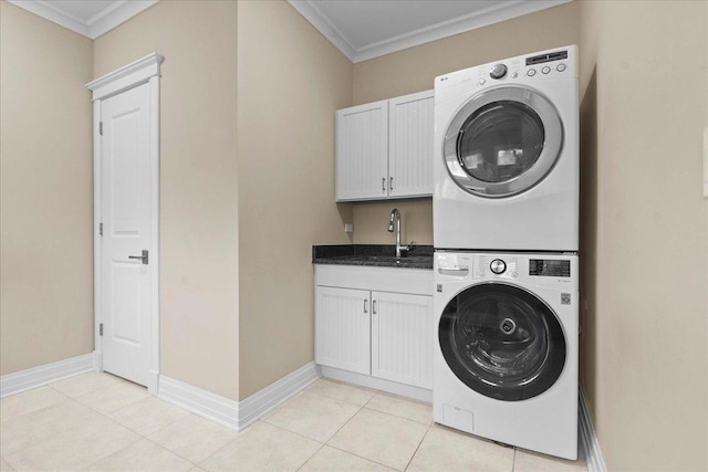 laundry room with a sink, cabinet space, crown molding, and stacked washer / drying machine
