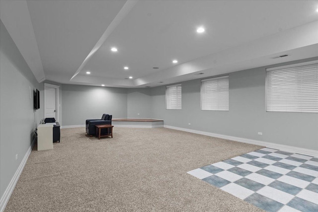 unfurnished room featuring a raised ceiling, baseboards, light colored carpet, and recessed lighting