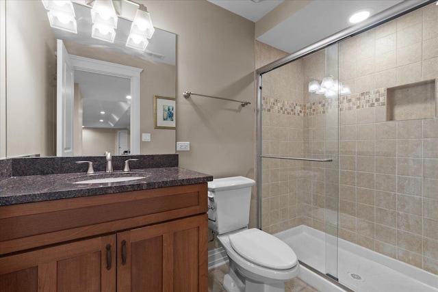 bathroom with a stall shower, toilet, and vanity