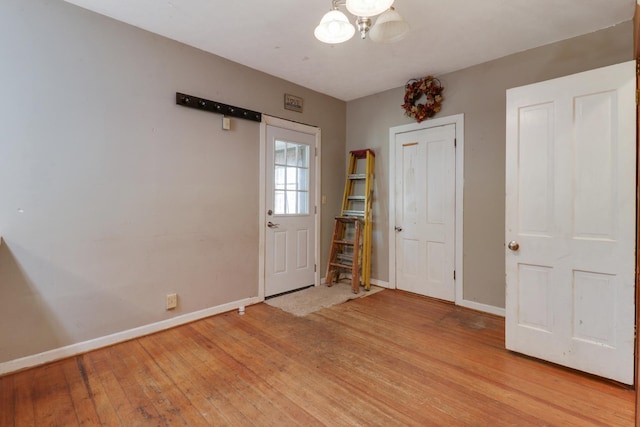 201 E Boundary St, Stanford, IL 61774 - unfurnished room with light wood-style flooring, baseboards, and a chandelier