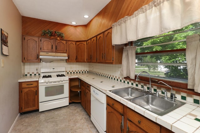 201 E Boundary St, Stanford, IL 61774 - kitchen featuring white appliances, under cabinet range hood, tile countertops, decorative backsplash, and a sink