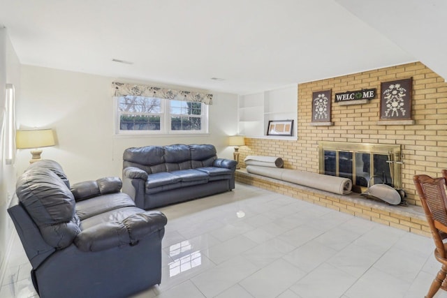 living area featuring a brick fireplace and visible vents