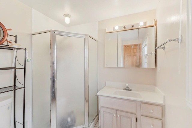 bathroom with a shower stall, vanity, and toilet