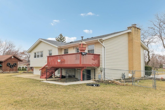 back of property with a chimney, a gate, stairs, fence, and a lawn