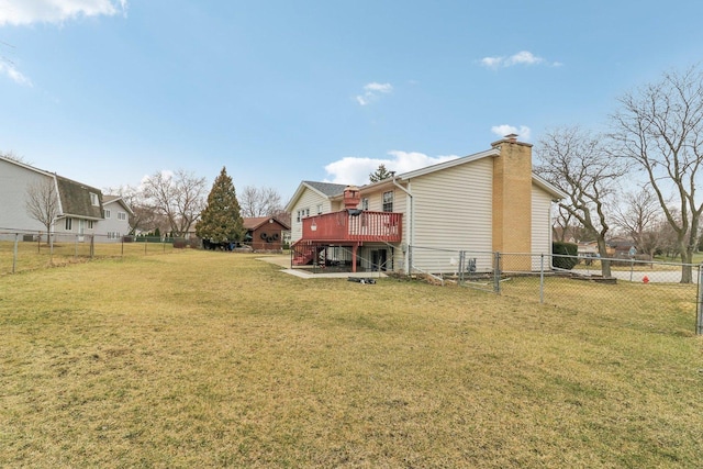back of house featuring a deck, a fenced backyard, and a lawn