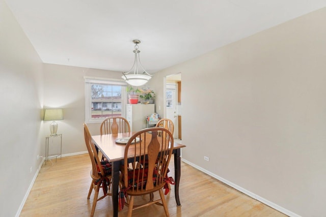 dining room featuring light wood finished floors and baseboards