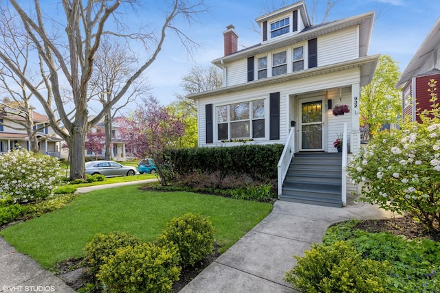 american foursquare style home featuring a front yard