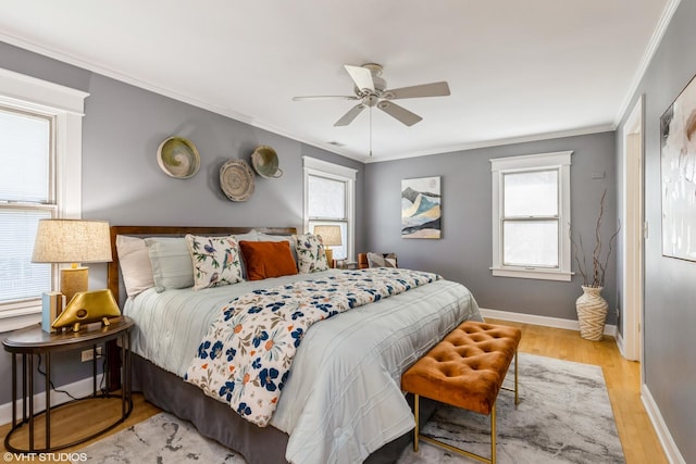 bedroom featuring wood finished floors, crown molding, baseboards, and ceiling fan