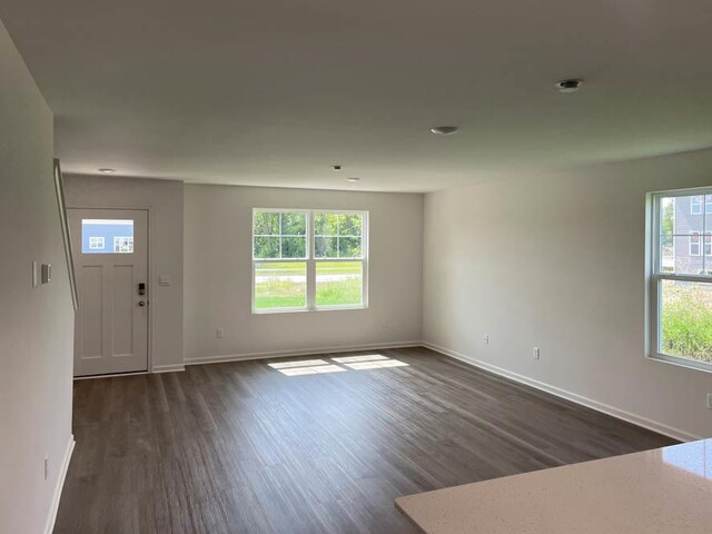 interior space with baseboards and dark wood-style flooring